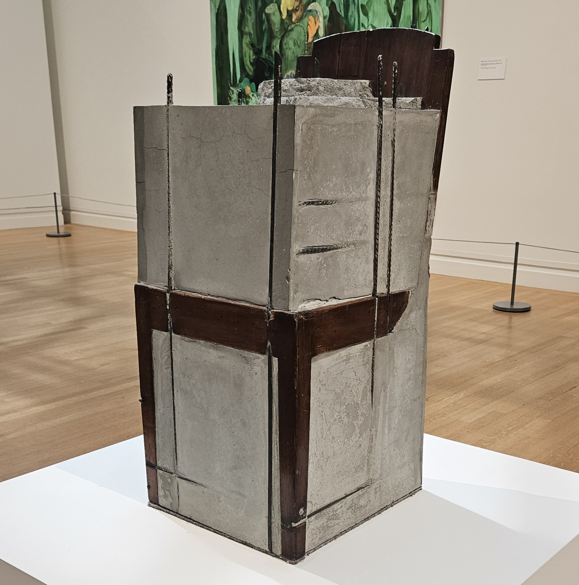 A wooden chair, encased in concrete and pierced with metal rods.
